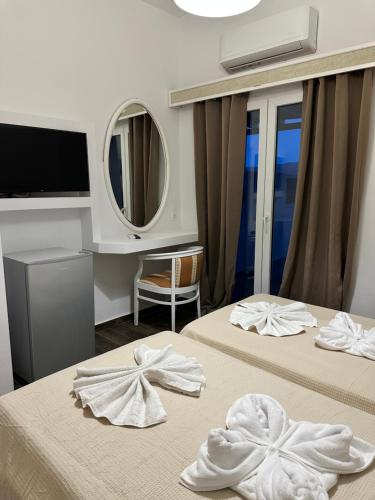 a hotel room with two beds with towels on them at ENE’S Mýkonos in Klouvas