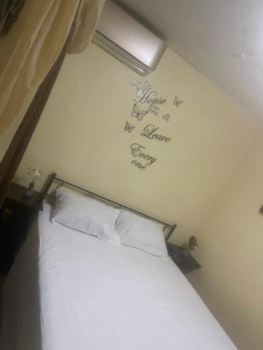 a bedroom with a bed with writing on the wall at Jamaican R Home in Kingston