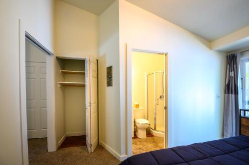 a bedroom with a bed and a bathroom with a toilet at Blue House - private 2 bed, 2 bath home with garage in Eugene