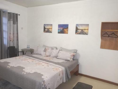 sypialnia z łóżkiem z czterema obrazami na ścianie w obiekcie Wisroc Oasis w mieście Linden