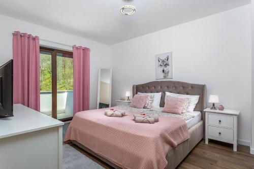 - une chambre avec un grand lit et des rideaux roses dans l'établissement House Mint, à Matulji
