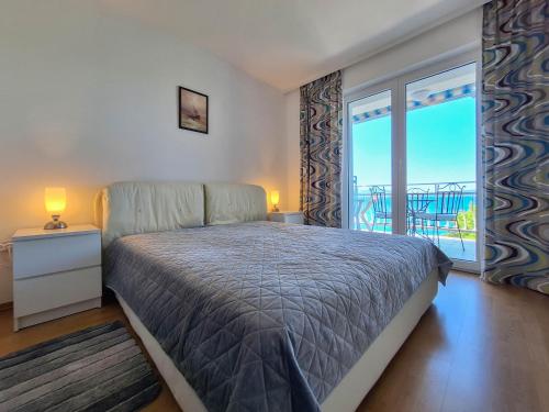 a bedroom with a bed and a large window at Apartment Selce in Selce