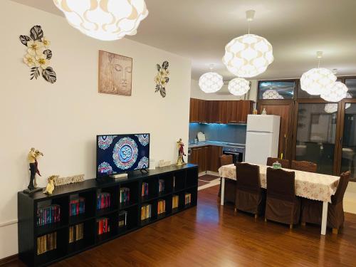 A.U.M House في بوخارست: غرفة معيشة مع طاولة طعام ومطبخ