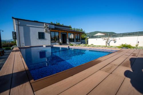 a house with a swimming pool and a wooden deck at Palomino house in Sinj