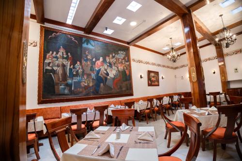 a dining room with tables and a painting on the wall at Hotel Hacienda Cusco Plaza in Cusco