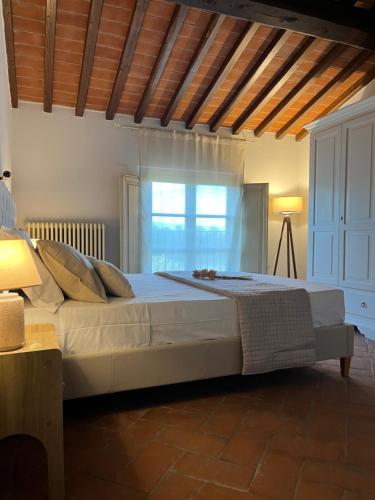 a bedroom with a large white bed with a window at My Tuscany Relais in Altopascio