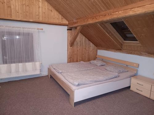 a bedroom with a bed and a wooden ceiling at Ubytování Háj in Jindřichovice