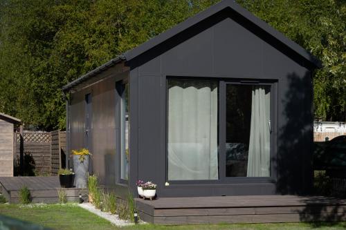 a black shed with a porch and a window at Domki Stolem in Jastarnia