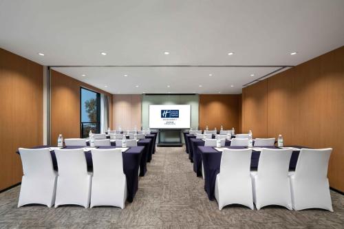 a conference room with chairs and a projection screen at Holiday Inn Express Chengdu Gulou-Tianfu Square Chunxi Road Branch in Chengdu