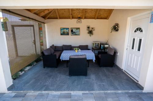 a patio with a table and chairs and a couch at Palomino house in Sinj