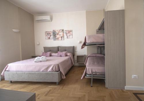 a bedroom with two beds with pink sheets at B&B Il Quadrifoglio in Portici
