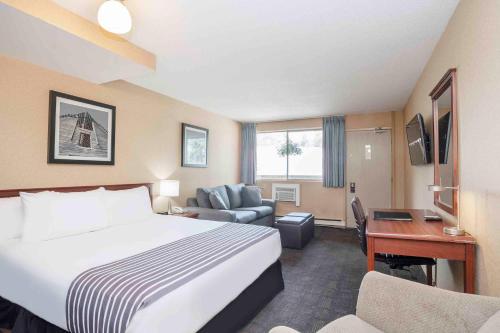 a hotel room with a bed and a desk at Sandman Inn Princeton in Princeton