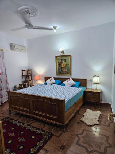 1 dormitorio con cama con sábanas azules y techo en Casa Helvetica, en Luxor