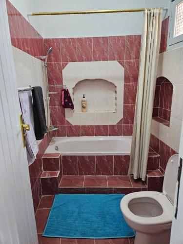 y baño con bañera y aseo. en Casa Helvetica, en Luxor