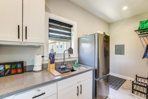 a kitchen with white cabinets and a stainless steel refrigerator at Modern Studio Suite in Sandy Point on Lummi Bay! in Ferndale
