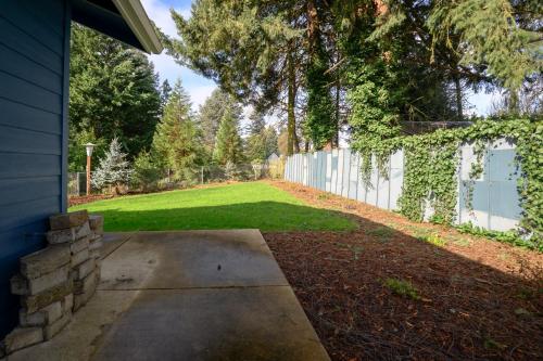 a backyard with a fence and a grass yard at Blue House - private 2 bed, 2 bath home with garage in Eugene