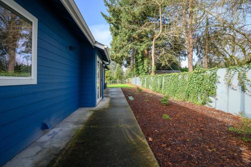 a blue house with a sidewalk next to a fence at Blue House - private 2 bed, 2 bath home with garage in Eugene