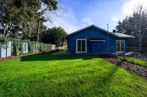 a blue house in a yard with a fence at Blue House - private 2 bed, 2 bath home with garage in Eugene
