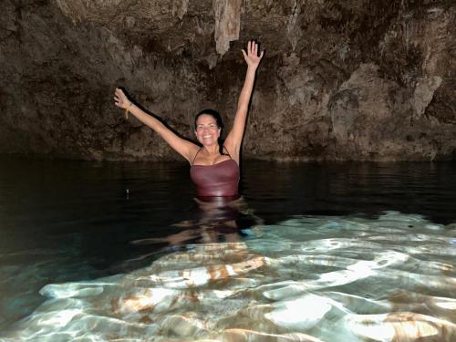 a woman standing in the water with her arms up at punta beach bavaro hotel apartamentos in Punta Cana
