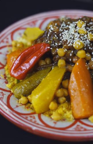 a red and white plate of food with vegetables and beans at Hôtel Restaurant BOUGAFER in Oulad Akkou