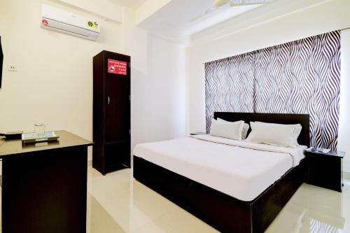 a bedroom with a bed with a black and white headboard at Hotel O Home Cozy Home in Guwahati