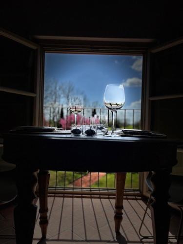 two wine glasses sitting on a table in front of a window at My Tuscany Relais in Altopascio
