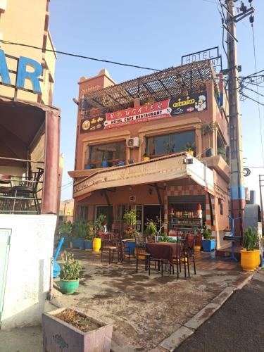 a restaurant with tables and chairs in front of a building at Hôtel Restaurant BOUGAFER in Oulad Akkou
