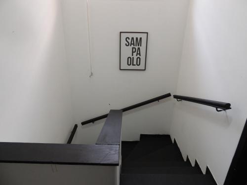 a sign on a wall above a staircase with a sign on it at room itaim in Sao Paulo