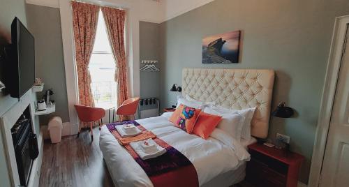 1 dormitorio con 1 cama grande con almohadas rojas en Highlander House B&B en Rothesay
