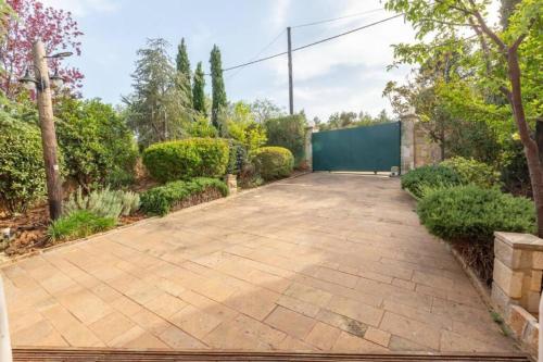 a brick driveway with a green wall in a garden at Lilian Luxury Villa Halkidiki in Nea Fokea