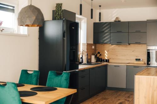 a kitchen with a black refrigerator and a wooden table at Apartmány Na Vŕšku in Kežmarok