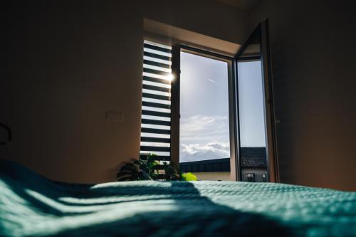 a bedroom with a bed and a window with a view at Apartmány Na Vŕšku in Kežmarok