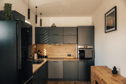 a kitchen with gray cabinets and a wooden table at Apartmány Na Vŕšku in Kežmarok