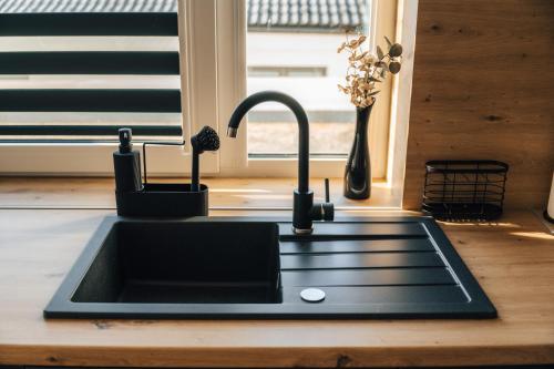 a kitchen sink with a faucet next to a window at Apartmány Na Vŕšku in Kežmarok