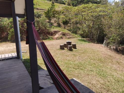a hammock on the porch of a house at Casa Roble Cabaña romántica en la montaña de Costa Rica in San Cristóbal Sur