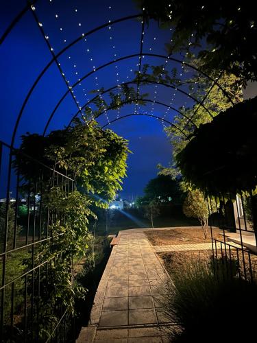 a walkway under an arch with lights at night at Villa Number 6 - apartment complex in Skopje