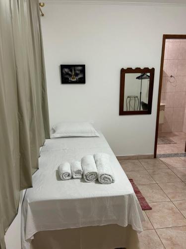 a bedroom with a bed with towels on it at Quarto para solteiro(a). in São José dos Campos