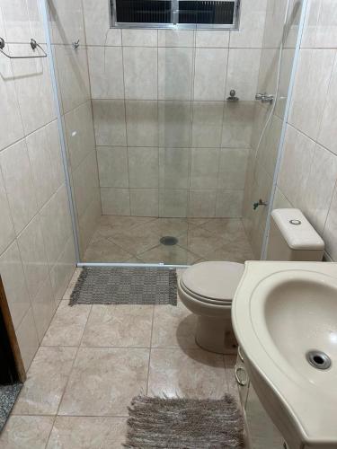 y baño con ducha, aseo y lavamanos. en Quarto para solteiro(a)., en São José dos Campos