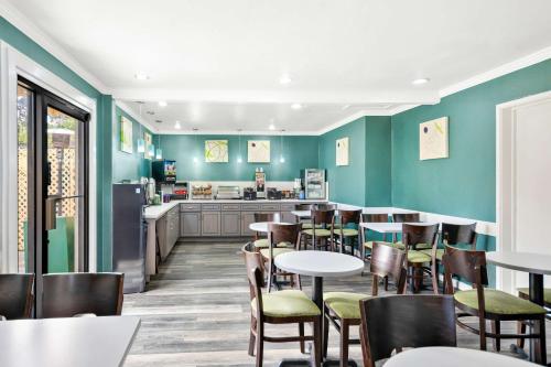 a restaurant with green walls and tables and chairs at Best Western Park Crest Inn in Monterey