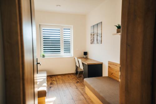 a room with a desk and a bed and a window at Apartmány Na Vŕšku in Kežmarok
