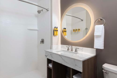 a bathroom with a sink and a mirror at Best Western Plus Pepper Tree Inn in Santa Barbara