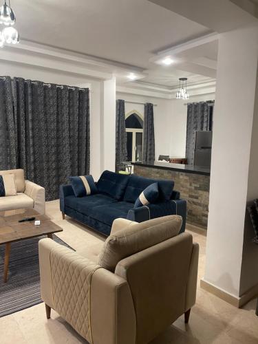 a living room with a blue couch and chairs at Neama town in Sharm El Sheikh