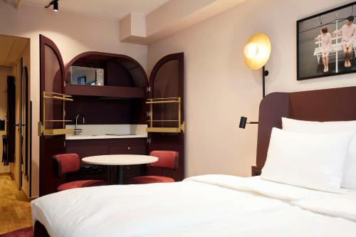 um quarto de hotel com uma cama e uma cozinha em Scandic München Macherei em Munique