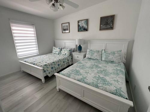 um quarto com 2 camas e uma ventoinha de tecto em Waterfront Tropical Getaway em Key Largo