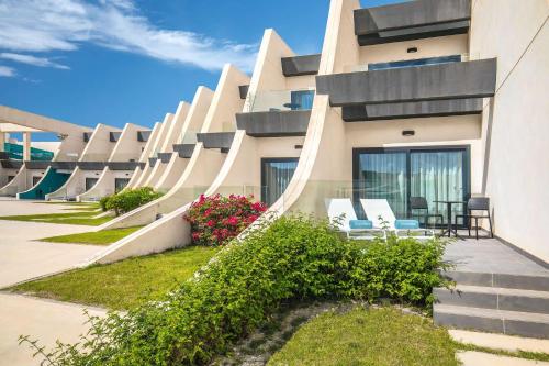 un bâtiment avec des chaises et des fleurs devant lui dans l'établissement Occidental Mar Menor, à Carthagène