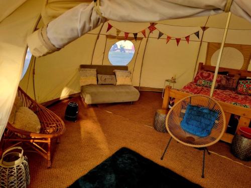 Cette chambre comprend une tente avec un lit et des chaises. dans l'établissement Luna Tent Secret garden Glamping, 