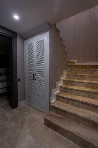 a staircase in a house with a white door at Marje Villas Bodrum in Bodrum City