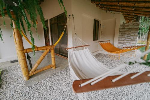 a hammock in a room with a house at Casa vacacional Olon in Olón
