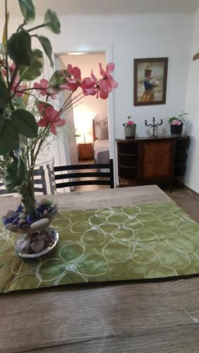 a table with a green table cloth and a vase with flowers at Cabañas Toto Península Beach in Totoralillo