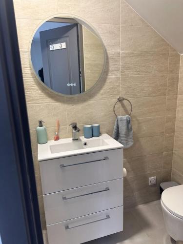 une salle de bain avec un lavabo blanc et un miroir dans l'établissement Chambre privée pour 4 personnes en banlieue parisienne à Bondy, à Bondy